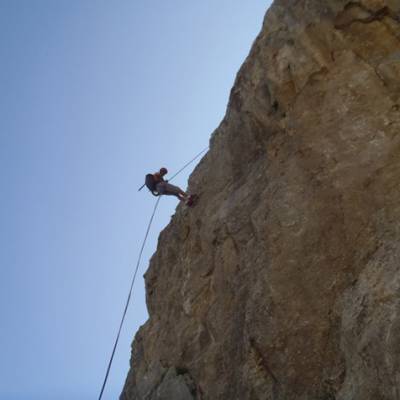 Rock Climber abseiling down cliff